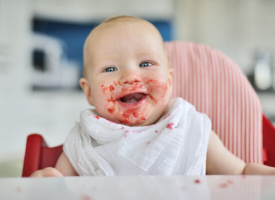 baby in the kitchen with food around his mouth